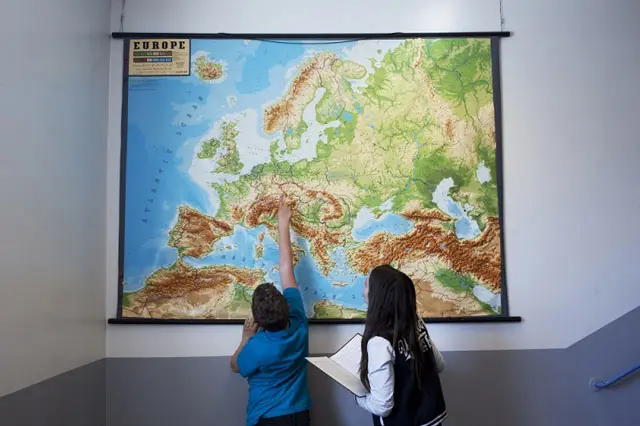 Barn tittar och pekar på världskarta