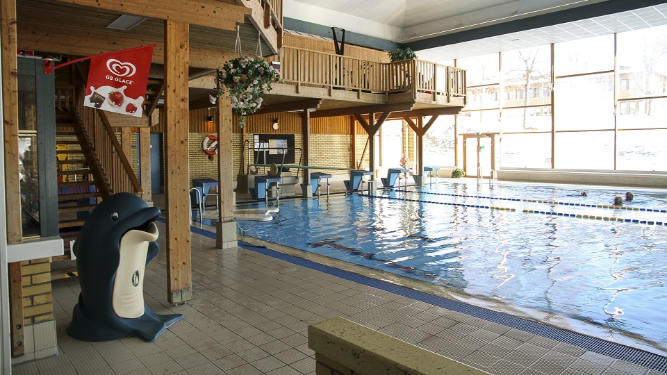 Bild på simhallens miljö där man ser en del av stora bassängen och kiosken.