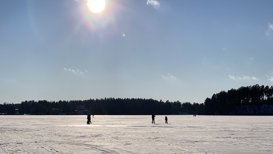 Personer ute på isbelagd Mullsjö en solig vinterdag