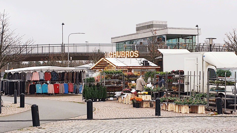 Vy över torget i Mullsjö. Torgförsäljning av kläder, blommor och churros.