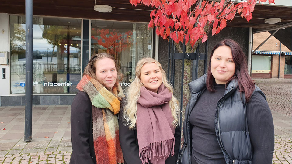 Tre leende kvinnor utanför kommunhusets entré