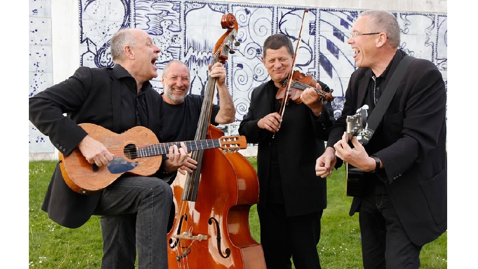 Fyra bandmedlemmar som spelar gitarr, violin och bas.
