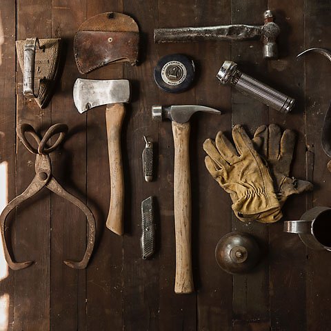 Närbild på gamla verktyg som yxa, hammare, tång